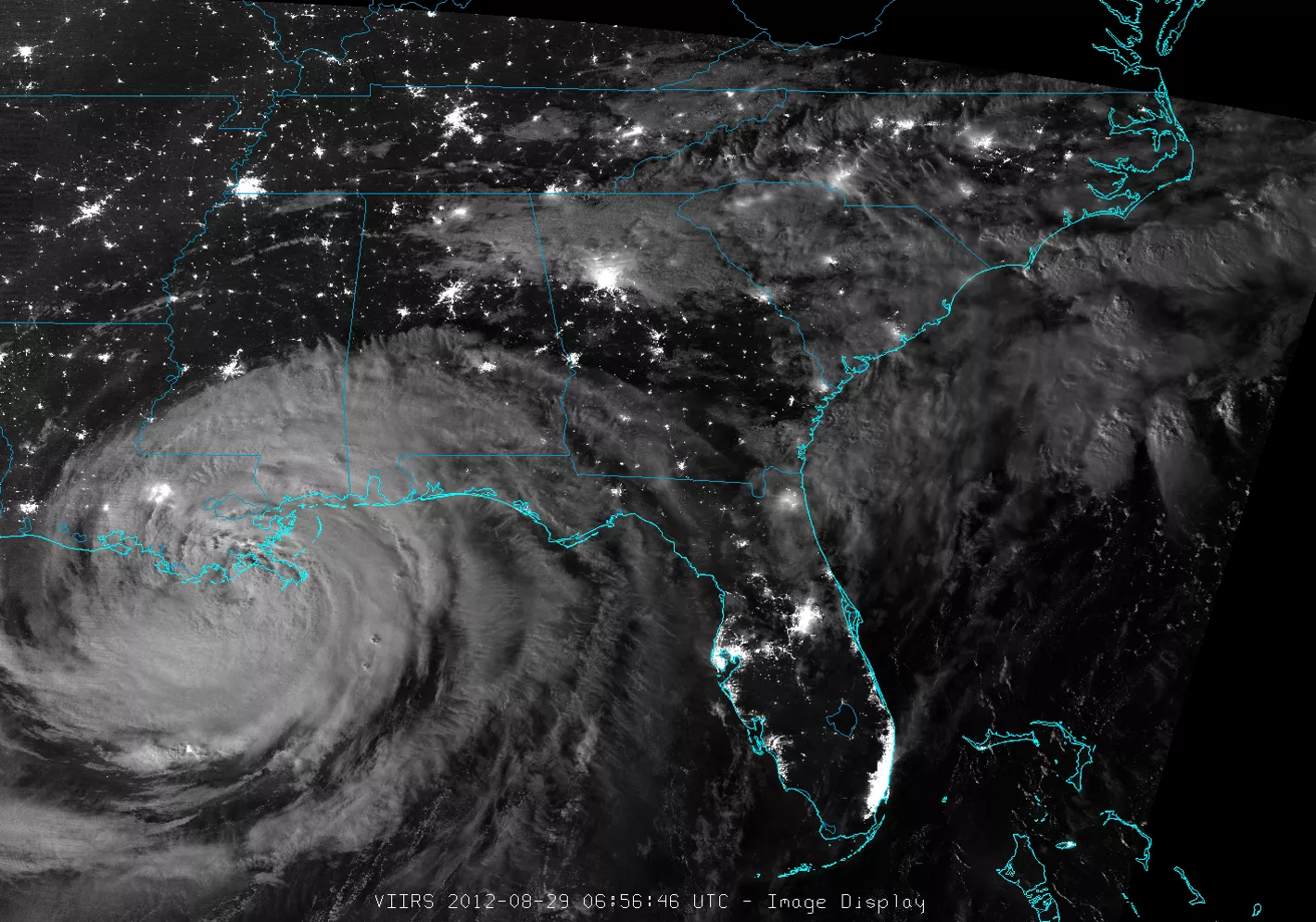 Nighttime image of the U.S. southeast coast showing city lights from Arkansas to North Carolina, while Hurricane Isaac, as a large rounded area of clouds, makes landfall in Louisiana.